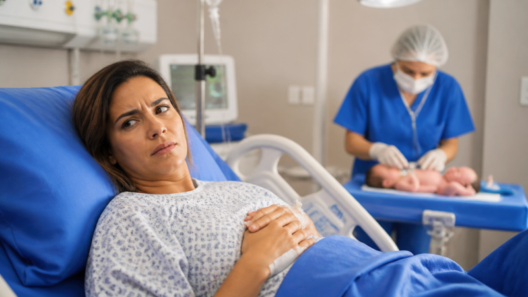 Mãe em maternidade observa avaliação do recém-nascido após o parto em ambiente hospitalar