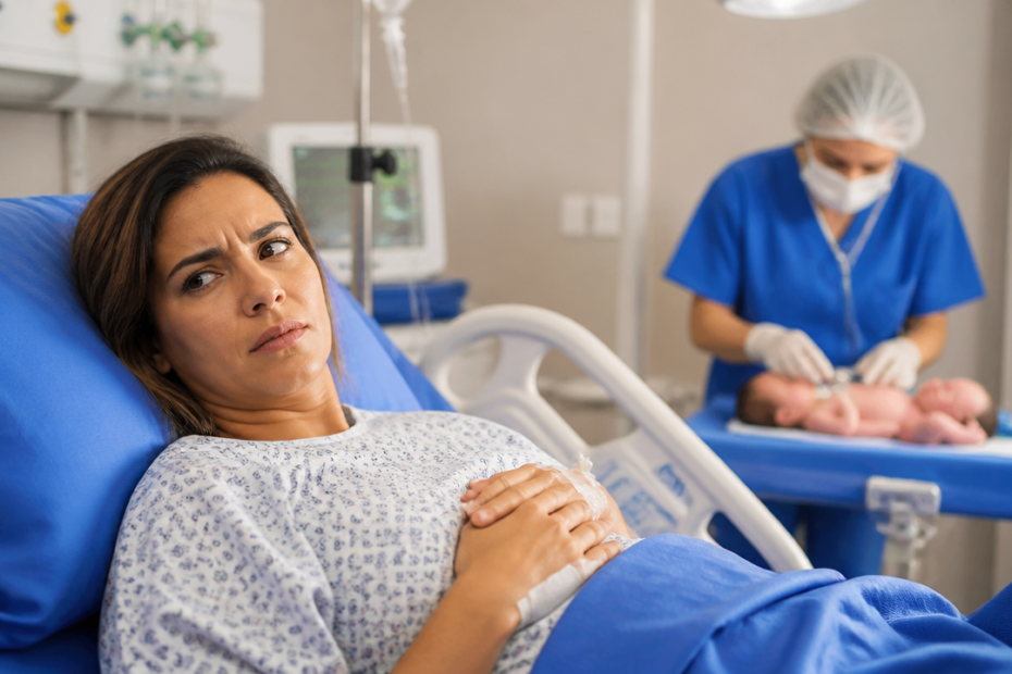 Mãe em maternidade observa avaliação do recém-nascido após o parto em ambiente hospitalar